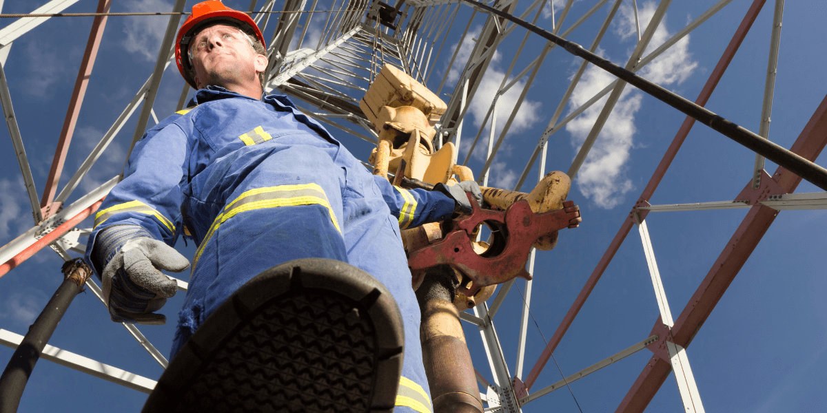 Oilrig worker using a slip type elevator to move pipe