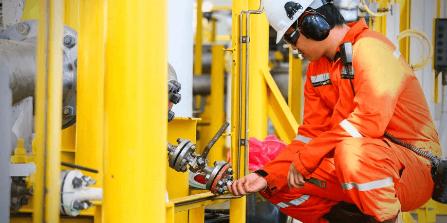 Oilfield worker doing repairs and maintenance on a rig.