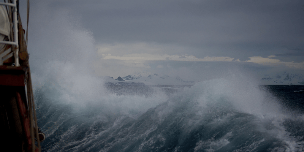 Waves crashing into an oilrig offshore.