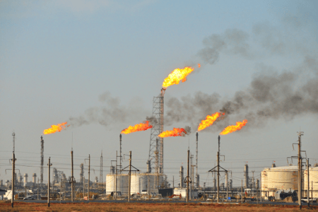 An oil refinery burning flares into the sky.